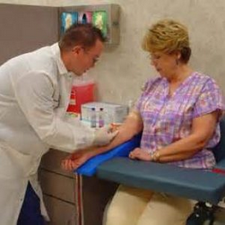 Phlebotomist holding patients hand