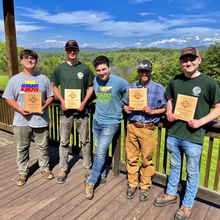 Students stand displaying awards won
