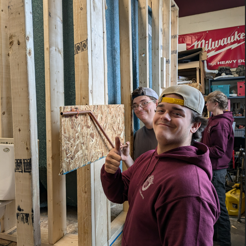 Smiling student gives a thumbs up to show he is pleased with his angle offset of copper pipe.