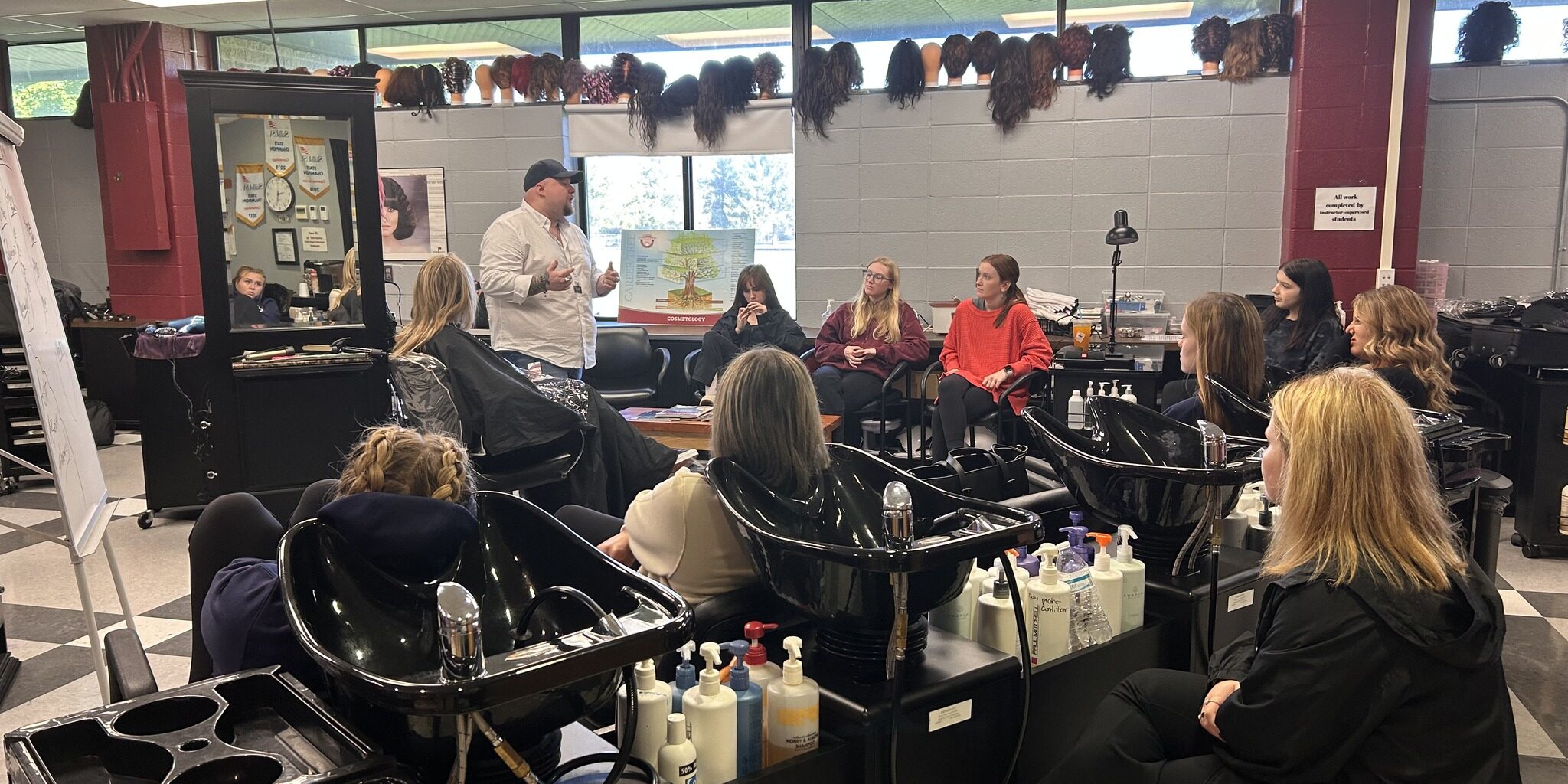students observe a guest speaker in the salon
