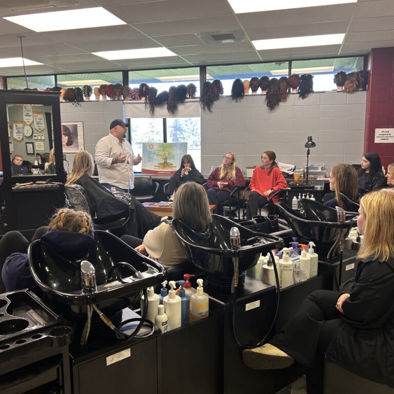students observe a guest speaker in the salon