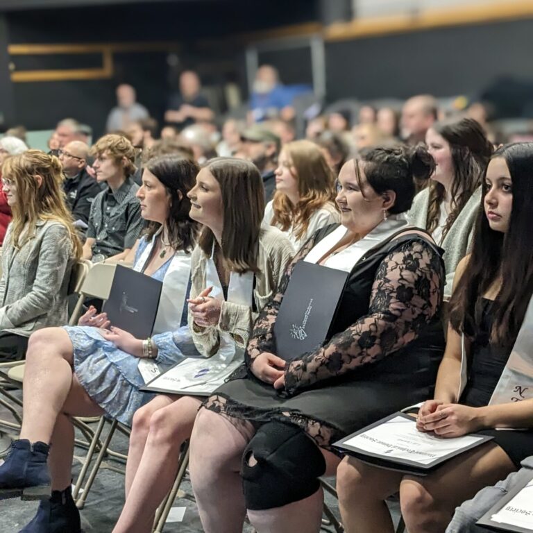 Students sit in chairs facing slightly left. They appear to be listening