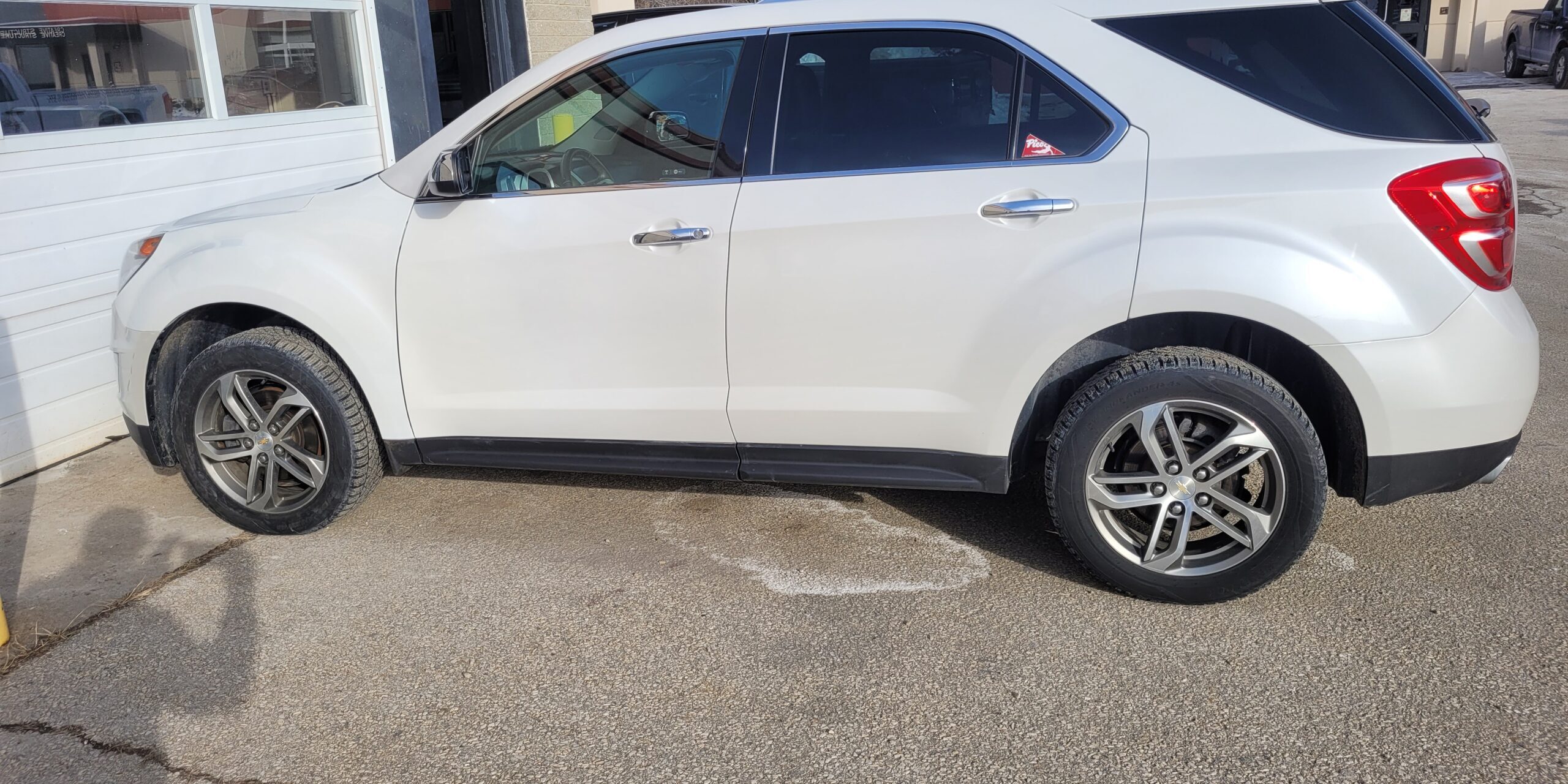 A white four door vehicle that looks brand new.