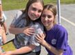Two students are smiling as they pose for the camera